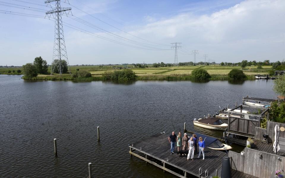 Bewoners van Zuiderburen bij het water, met op de achtergrond de bestaande hoogspanningsmasten